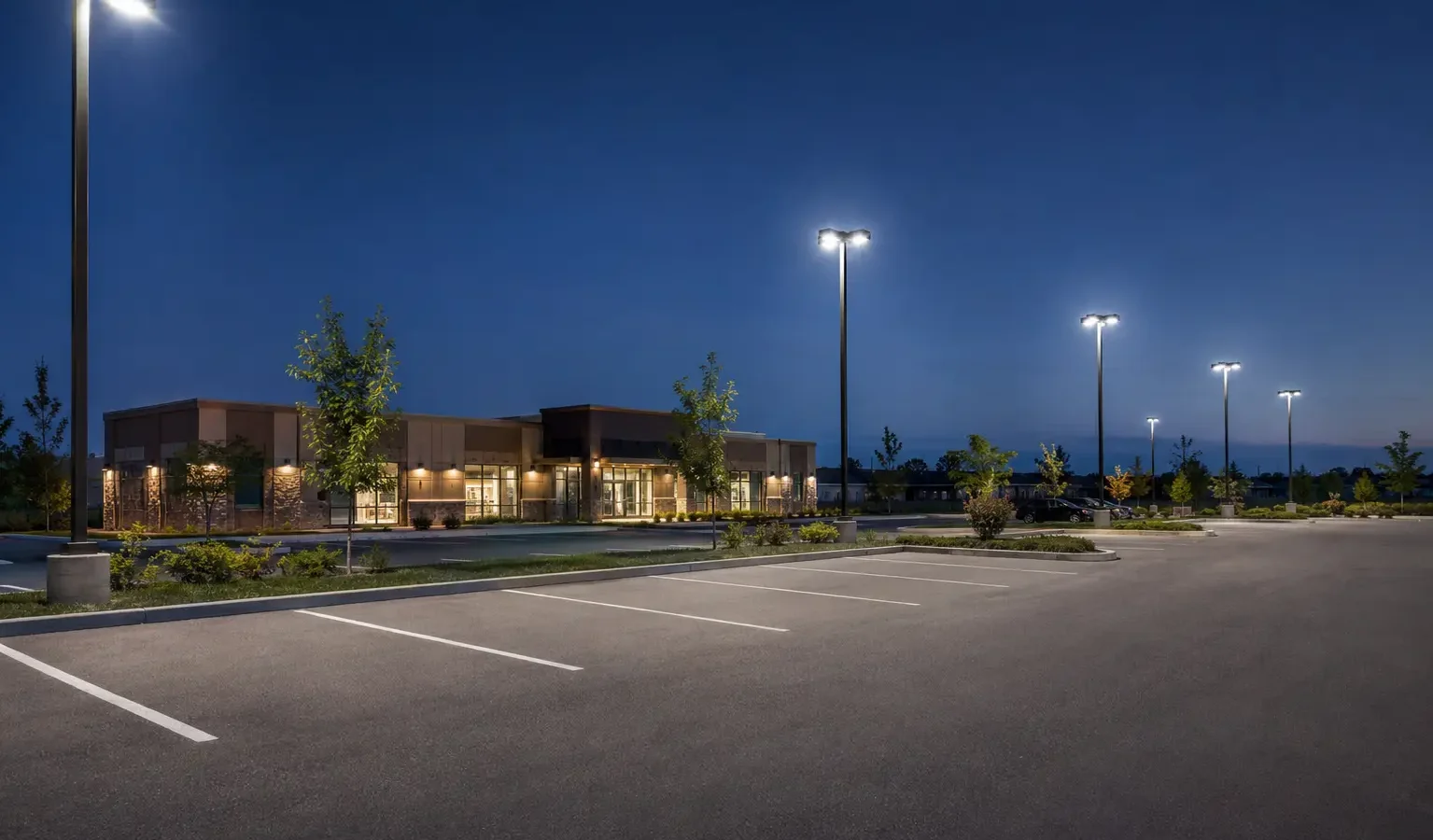 Commercial parking lot at dusk with LED pole lighting