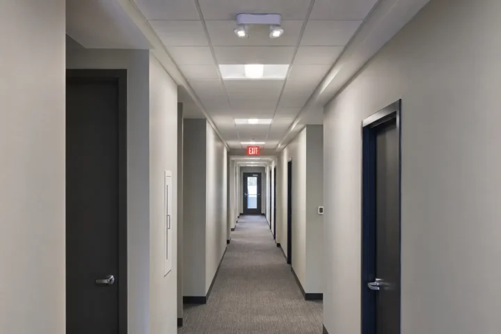 Commercial corridor with emergency lighting and illuminated exit sign