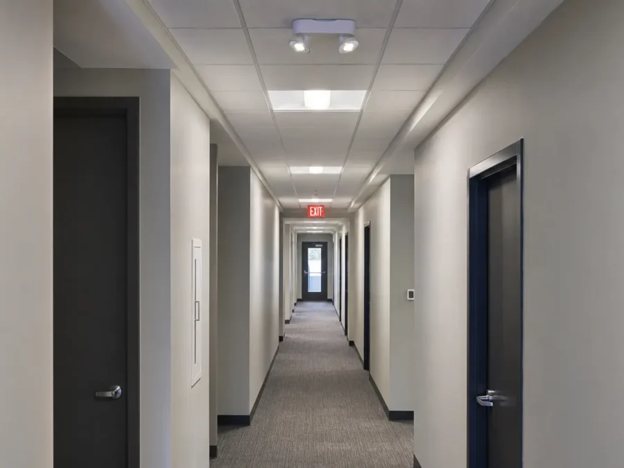 Commercial corridor with emergency lighting and illuminated exit sign